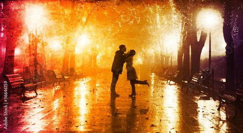 Photo: Couple walking at alley in night lights. Couple walking at alley in night lights.