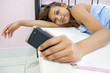 Young beautiful woman with mobile in bed