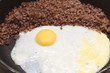 Cooked eggs with buckwheat on fruing pan closeup