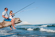 Fishing - little girl fishing with father at the beach
