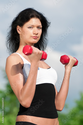 Photo: Woman doing exercise with dumbbell Woman doing exercise with dumbbell