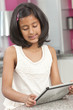 Asian Indian Girl Child Using Tablet Computer at Home