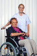 Krankenpflegerin und alte Frau im Rollstuhl
