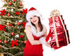 Christmas girl in santa holding stack gift box.
