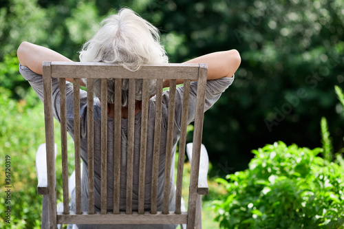 Foto: grauhaarige Frau entspannt im Garten grauhaarige Frau entspannt im Garten