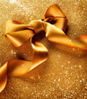 Greeting Card. Gold Bow on a Blinking Background