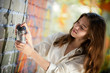 teenage girl portrait with spray can near graffiti wall