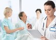 Doctor making notes at patients bed