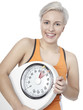 Foto: Young woman with scale is happy to lose weight Young woman with scale is happy to lose weight