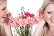 Junge Frau spricht durch die Blume, Frau horcht freudig zu