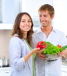 Young happy couple cooking together at home kitchen