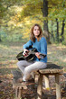 Young girl with guitar in forest, selective focus Young girl with guitar in forest, selective focus