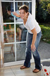 Junge Frau putzt Fenster