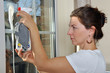 Junge Frau putzt Fenster