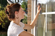 Junge Frau putzt Fenster