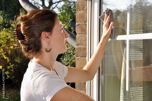 Foto: Junge Frau putzt Fenster Junge Frau putzt Fenster