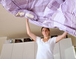 Junge Frau macht Bett
