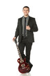 Photo: Full length of young man in a suit standing with guitar Full length of young man in a suit standing with guitar