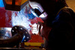 factory worker welding metal and sparks spreading