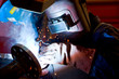 factory worker welding metal and sparks spreading