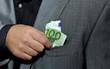 Photo: Hand steckt 100 Euro in Jacket Hand steckt 100 Euro in Jacket