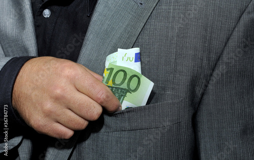 Photo: Hand steckt 100 Euro in Jacket Hand steckt 100 Euro in Jacket