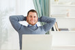 Smiling businessman leaning back in his homeoffice
