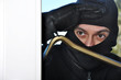 Einbrecher schaut durch Fenster