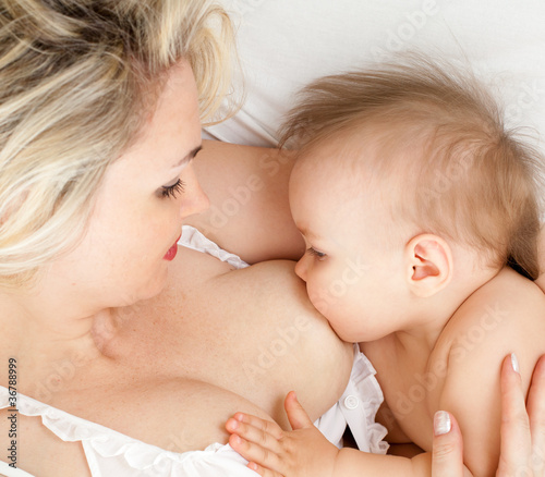 Foto: mother breast feeding her child, focus on the child mother breast feeding her child, focus on the child