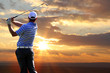 Man playing golf against sunset