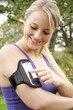 Foto: Junge Frau beim Joggen mit Smartphone Junge Frau beim Joggen mit Smartphone