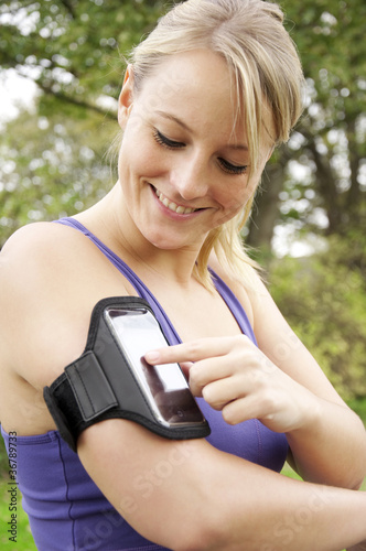 Photo: Junge Frau beim Joggen mit Smartphone Junge Frau beim Joggen mit Smartphone