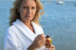 Smiling woman in toweling robe eating fruit salad