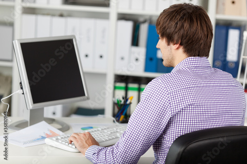 Photo: junger mann arbeitet am computer junger mann arbeitet am computer