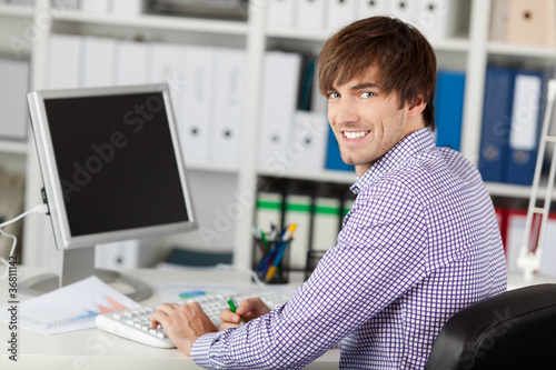 Photo: lächelnder geschäftsmann arbeitet am computer lächelnder geschäftsmann arbeitet am computer