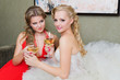 The bride and her bridesmaid with a glass of wine