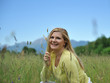 Pretty healthy summer woman outdoors on green field in Alps enjo