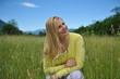Pretty healthy summer woman on green field in Alps. Switzerland