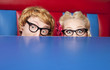 Nerdy couple hiding behind a table