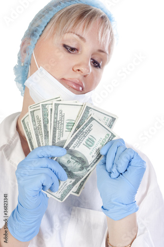 Photo: Doctor holding money on isolated background Doctor holding money on isolated background