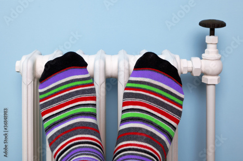 Photo: Warming feet on the radiator Warming feet on the radiator