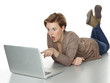 Pretty girl with laptop lying on the floor is very surprised