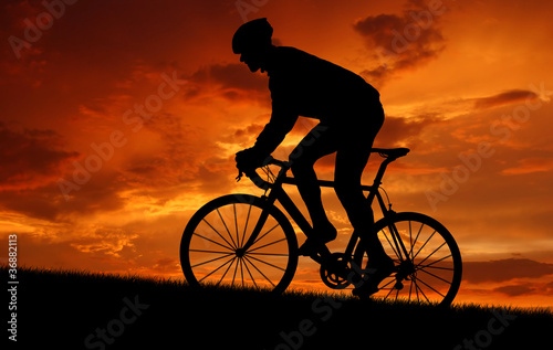 Photo: silhouette of the cyclist riding a road bike at sunset silhouette of the cyclist riding a road bike at sunset