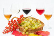 Foto: Uva bianca, bacche rosse e calici di vino su fondo bianco Uva bianca, bacche rosse e calici di vino su fondo bianco
