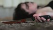 Conceptual footage of a dead woman holding a sharp knife