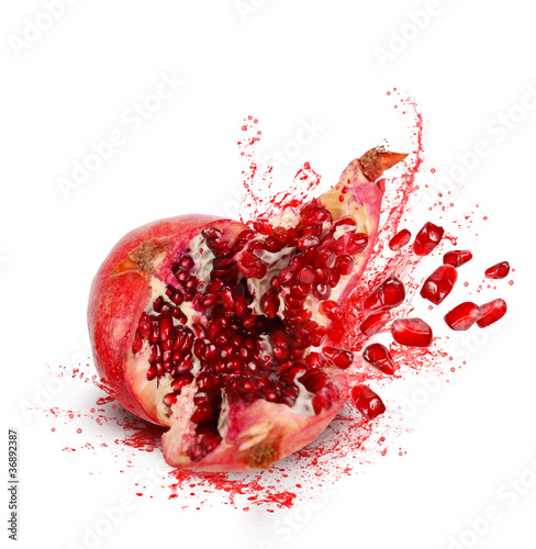 Photo: Falling and crack pomegranate with splashes of juice and seeds Falling and crack pomegranate with splashes of juice and seeds
