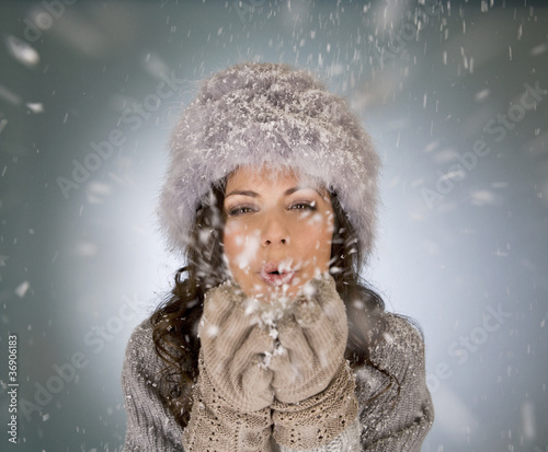 Photo: A young woman blowing snowflakes A young woman blowing snowflakes