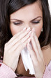 A young woman blowing her nose, close-up