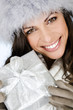 A young woman holding a Christmas present