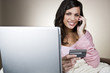 A young woman on the phone, holding her credit card